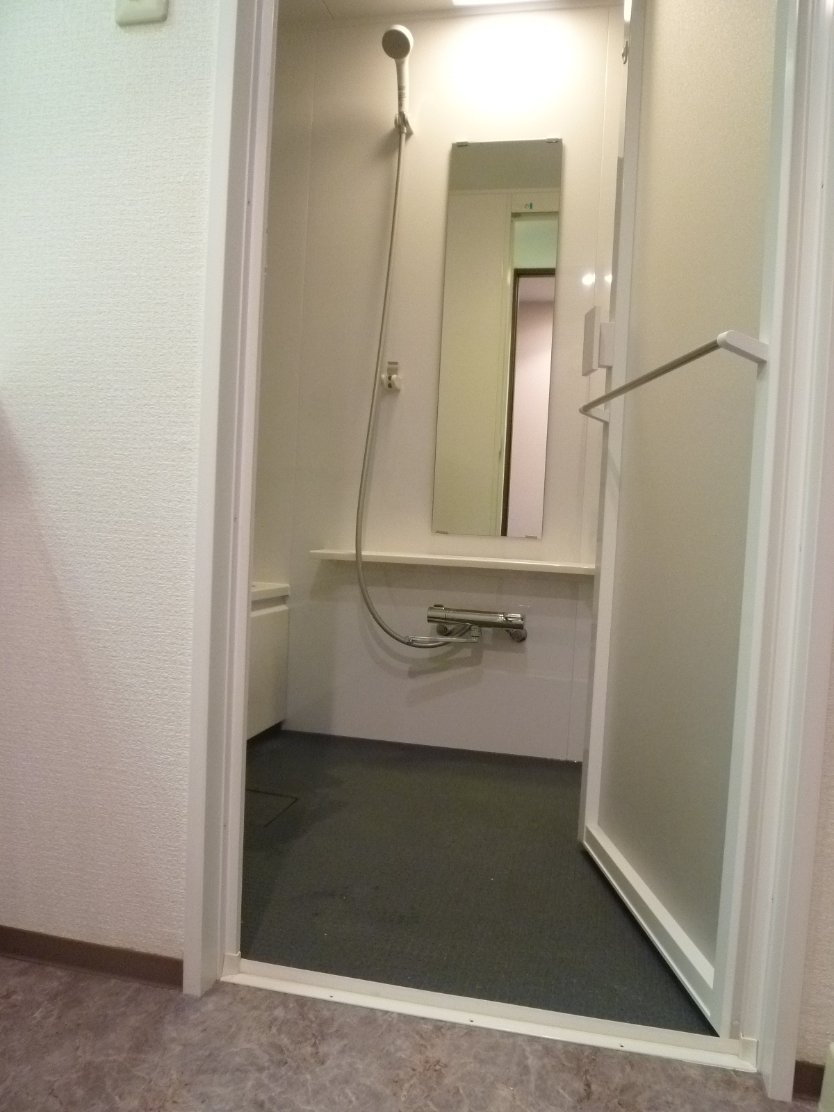 浴室入口<br />
扉は開き戸にして、ドアの外側にバスタオル掛けを付けました。<br />
